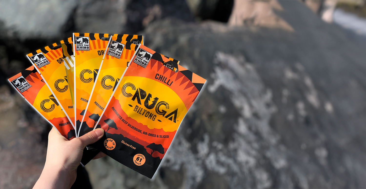 A hand holding a selection of Cruga Biltong, chilli and original flavours.